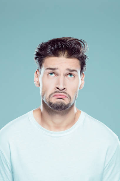 istock Confused young man on gray background 1131154324
