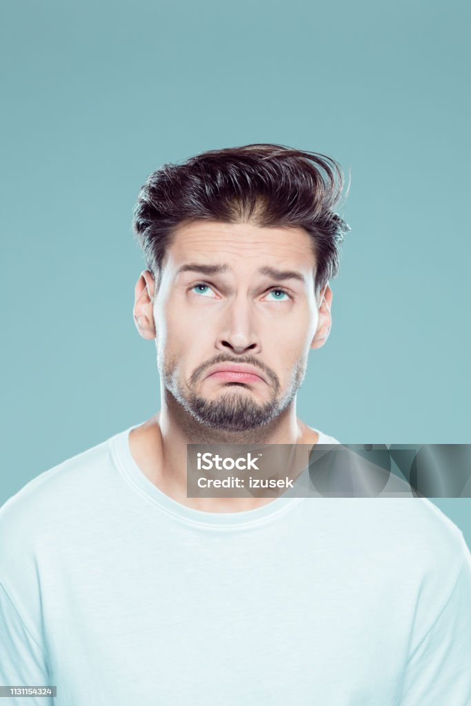 Confused young man on gray background Close up portrait of young caucasian man with confused facial against gray background 25-29 Years Stock Photo