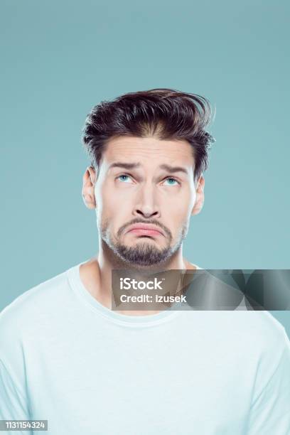 Confused Young Man On Gray Background Stock Photo - Download Image Now - 25-29 Years, Adult, Adults Only
