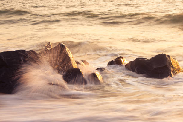 istock Long Exposure Of Beach Waves Hitting Rock At Sunset 1131154486