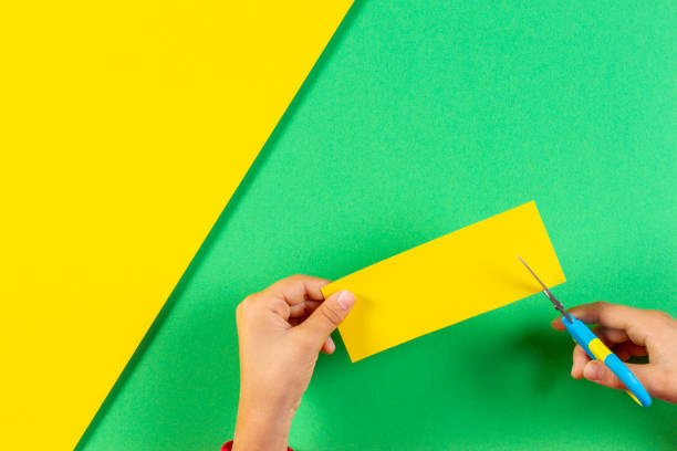istock Kid's hands cutting blue color paper with scissors 1131155362
