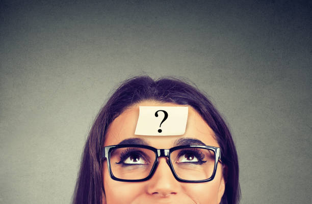 istock thinking woman with question mark on gray wall background 1131155706