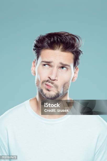 Young Man Making A Decision Stock Photo - Download Image Now - Confusion, Human Face, Men