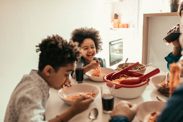 Family Lunch Cute family having lunch together. kids eating noodles stock pictures, royalty-free photos & images