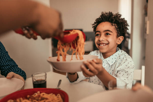 déjeuner en famille - child eating pasta spaghetti photos et images de collection