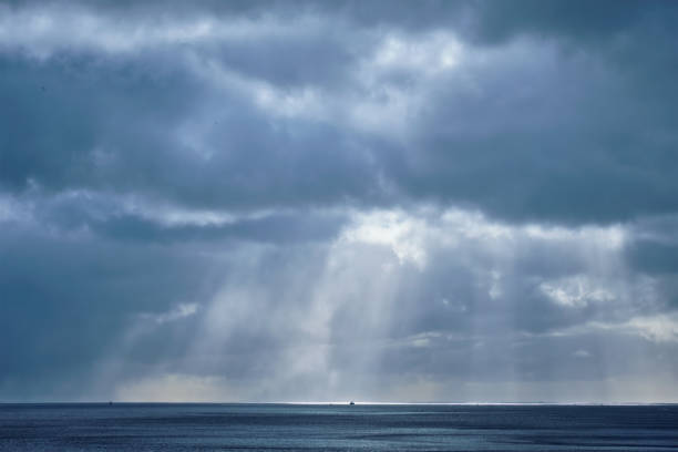 Norwegian sea in winter with sun rays through clouds. Lofoten islands, Norway