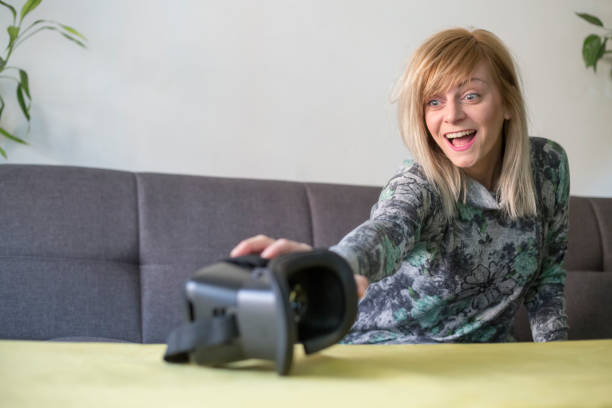 istock woman at home enjoying virtual reality goggles on sofa 1131160762