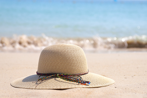 Summer hat on the tropical sand beach.