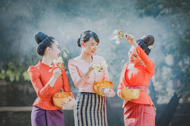 Thai girls and laos girls splashing water during Songkran festival, Thai girls and laos girls splashing water during Songkran festival,Water blessing ceremony of adults,Buddha statue water ceremony in songkran festival,Thailand traditional. silom stock pictures, royalty-free photos & images