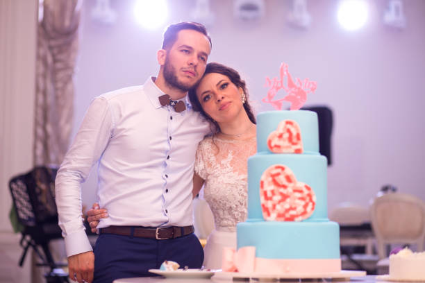 istock Beautiful wedding couple posing on their wedding day with the wedding cake 1131164446