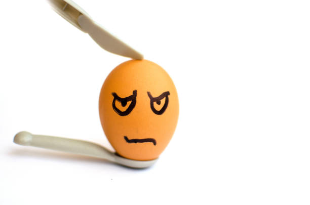 istock brown evil egg with a small knife and a spoon on white background 1131167878