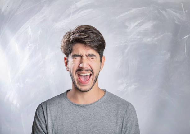 istock Young bearded man shouting angry portrait in studio 1131168050