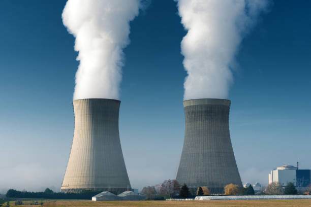istock two power plant cooling towers steaming on dark blue sky background 1131170230
