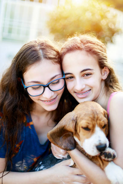 istock Young sisters hugging their puppy 1131170620