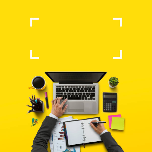 Office workplace with laptop, notebook, hand, office supplies, on yellow background. Solution, business planning, financial analysis, accounting, start up or working flat lay top view concept. stock photo