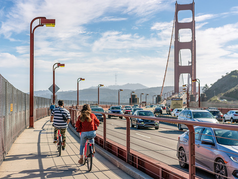 San Francisco, USA - A rear view of people cycling towards the Golden Gate Bridge, heading in the direction of San Francisco.