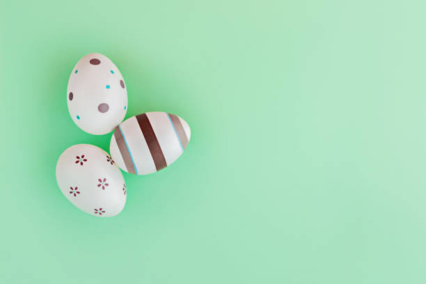 istock Eggs decorated with stripes and flowers on green background, Easter concept. 1131173661