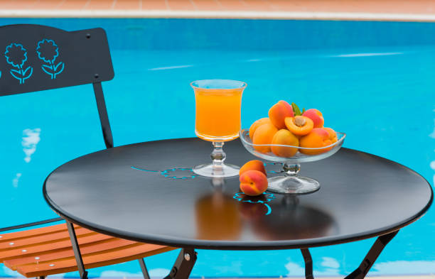 крупным планом свежие абрикосовые и фруктовые соки на обеденном столе в саду - orange black horizontal saturated color стоковые фото и изображения