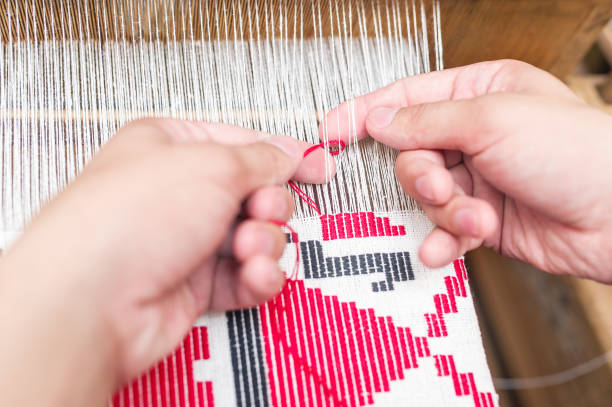 Hands of woman weaving color pattern on traditional hand-weaving wooden loom. Hands of woman weaving color pattern on traditional hand-weaving wooden loom. Closeup photo flax weaving stock pictures, royalty-free photos & images