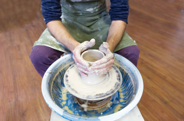 istock Creating a vase of white clay closeup. Master hands making clay jug. 1131174682
