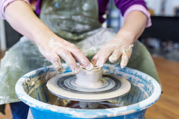 istock Man working on the potter's wheel. Hands sculpts a cup from clay pot. 1131174702