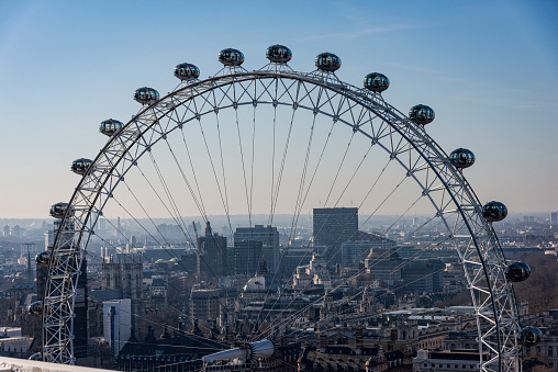 Close up of the London Eye. It show a half of the ferris wheel, Behind them, the panorama of London.