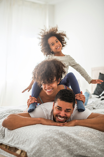African american family playing in bed.