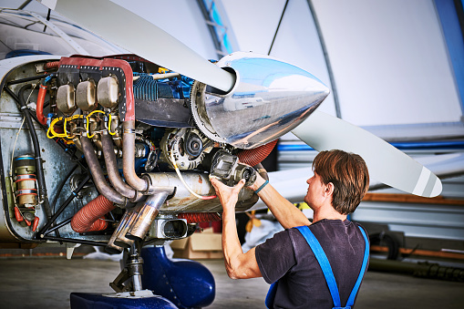 Removal and repair of an engine starter of an airplane by a service worker.