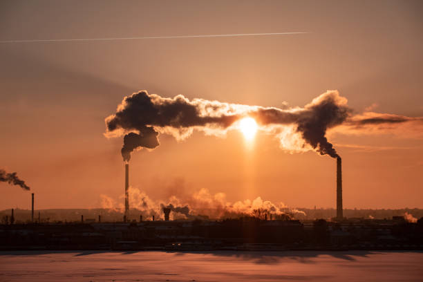 istock View of factory pipes emitting pollution into the atmosphere. Environmental problems. Sunset red sun 1131179994