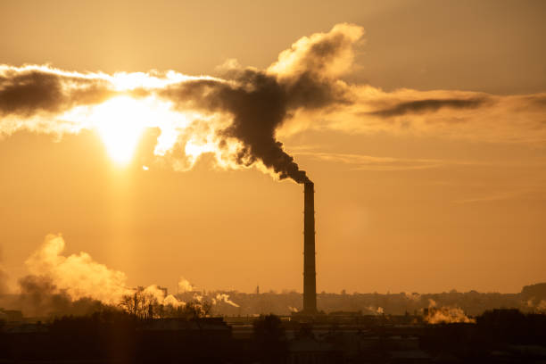 istock View of factory pipes emitting pollution into the atmosphere. Environmental problems. Sunset red sun 1131180024