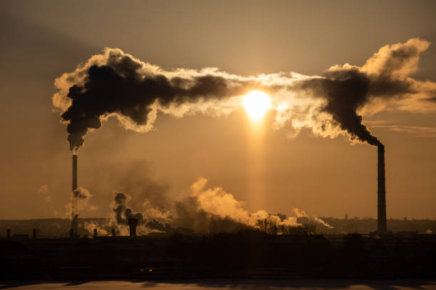 istock View of factory pipes emitting pollution into the atmosphere. Environmental problems. Sunset red sun 1131180055
