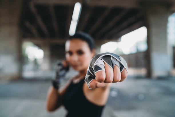 poderosa mujer joven golpeando - boxing combative sport defending protection fotografías e imágenes de stock