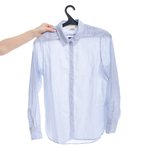 istock Blue shirt on hanger in hand 1131183657