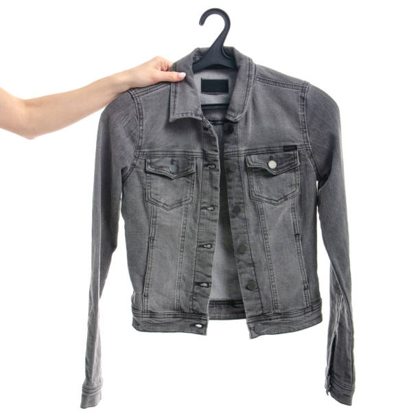 Gray denim jacket on a hanger in hand