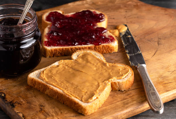istock Fixing a Peanut Butter and Jelly Sandwich on a Wooden Kitchen Counter 1131185676