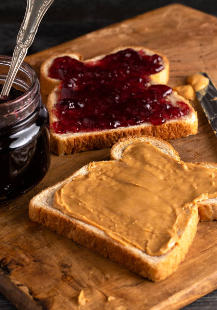 istock Fixing a Peanut Butter and Jelly Sandwich on a Wooden Kitchen Counter 1131185678