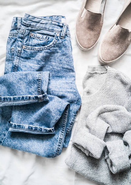 istock Women's spring clothes - mom's jeans, gray pullover and suede sneakers on a light background, top view 1131193620