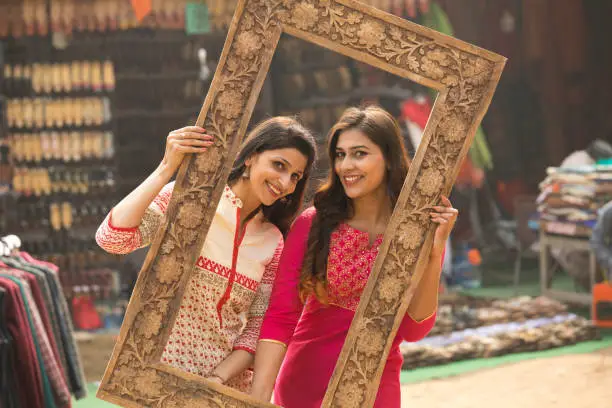 Two women friends posing together in a traditional picture frame