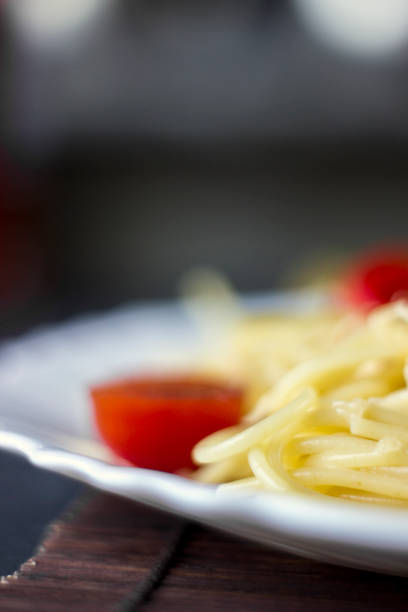 Spaghetti pasta in tomato sauce with cheese and parsley, macro. Italian spaghetti pasta over dark stone background.