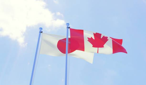 istock Japan and Canada, two flags waving against blue sky 1131196672