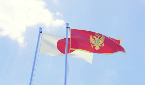 istock Japan and Montenegro, two flags waving against blue sky 1131196837