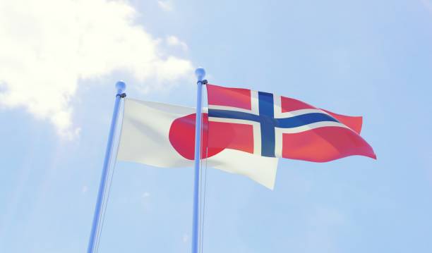 istock Japan and Norway, two flags waving against blue sky 1131196854