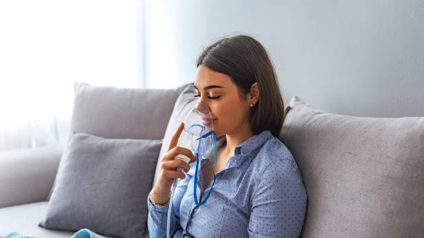 a mulher faz o nebulizador da inalação em casa. - nebulizer - fotografias e filmes do acervo