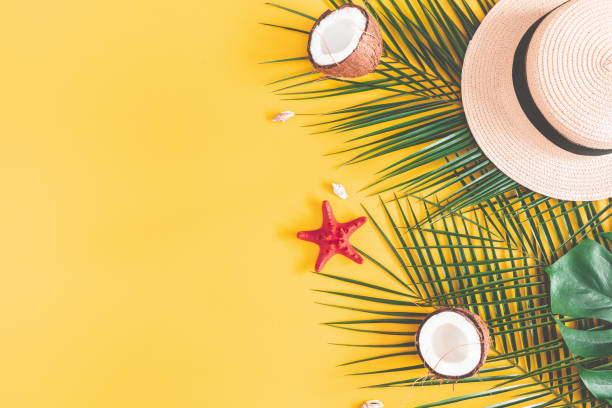 istock Summer composition. Tropical palm leaves, hat, coconut on yellow background. Summer concept. Flat lay, top view, copy space 1131196899