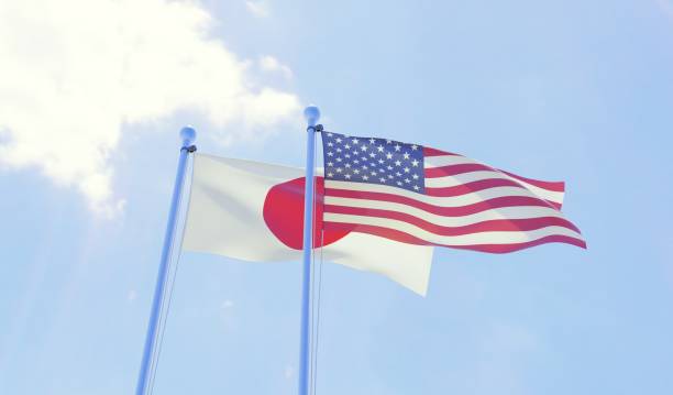 istock Japan and USA, two flags waving against blue sky 1131196927
