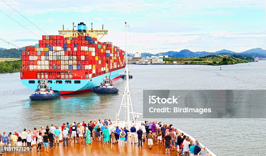 istock Cargo Container Ship entering the Panama Canal. Watched by Ship Passengers on Cruiseship Deck 1131197129