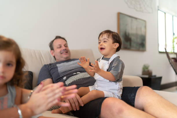 istock Down Syndrome Son having fun on sofa at home 1131198673