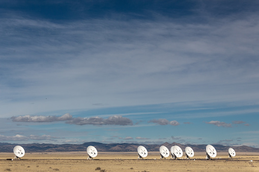 Very Large Array line of radio antenna dishes in the winter desert, space science and technology, horizontal aspect
