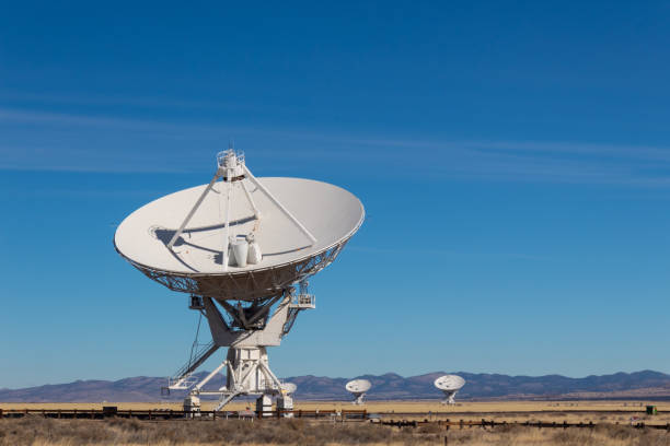 istock Very Large Array radio antenna dish close with others in distance, blue sky 1131201659
