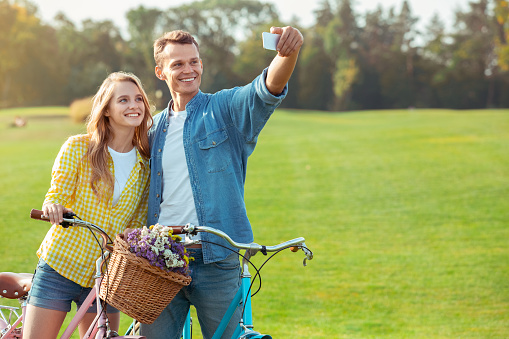 Young man and woman riding bicycle together ride